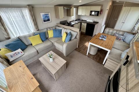 Interior view of the living room with dining space and kitchen in the background. 