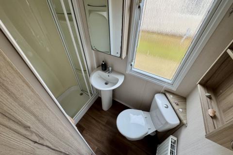 Interior of Bathroom with shower, toilet and sink. 
