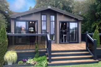 An ABI Lodge with exterior Decking area surrounded by Trees