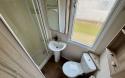 Interior of Bathroom with shower, toilet and sink. 