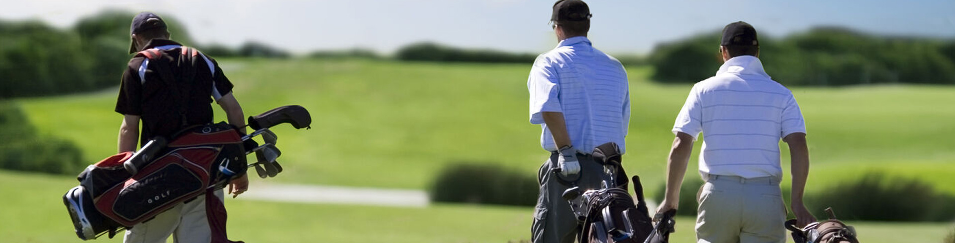 Three People pulling Trolley's on a Golf Course