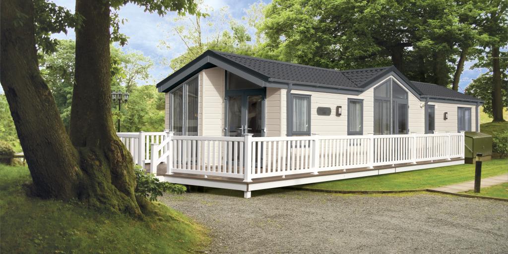 A White Holiday Home with exterior Decking area set within a Woodland area