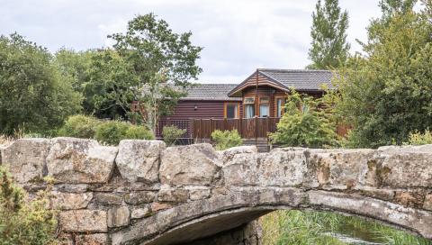 Traditional Wood Built Holiday Homes with a River running under a Bridge