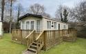 Exterior of a static caravan with a wooden decking.