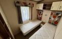 Twin bedroom with two single beds and over bed storage cupboards.