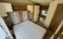 Master bedroom with double bed, in-build wardrobes and a vanity table and stool.