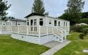 Exterior of a static caravan with a plastic decking.