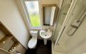 Interior view of bathroom with shower, sink and toilet