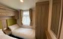 Twin bedroom with two single beds and a mirror. 