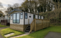 Exterior of static caravans with wooden decking. 